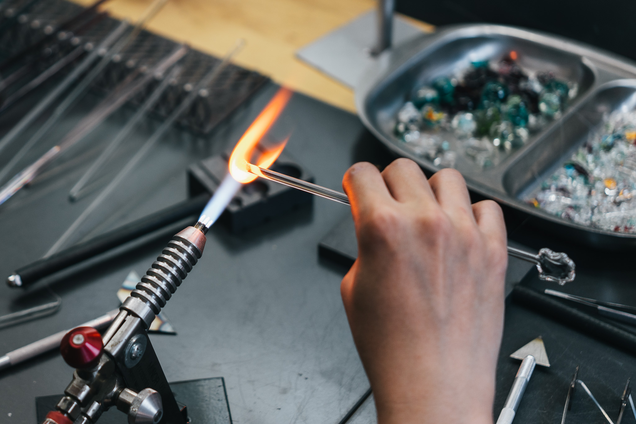 A clear glass rod being heated in the torch flame.