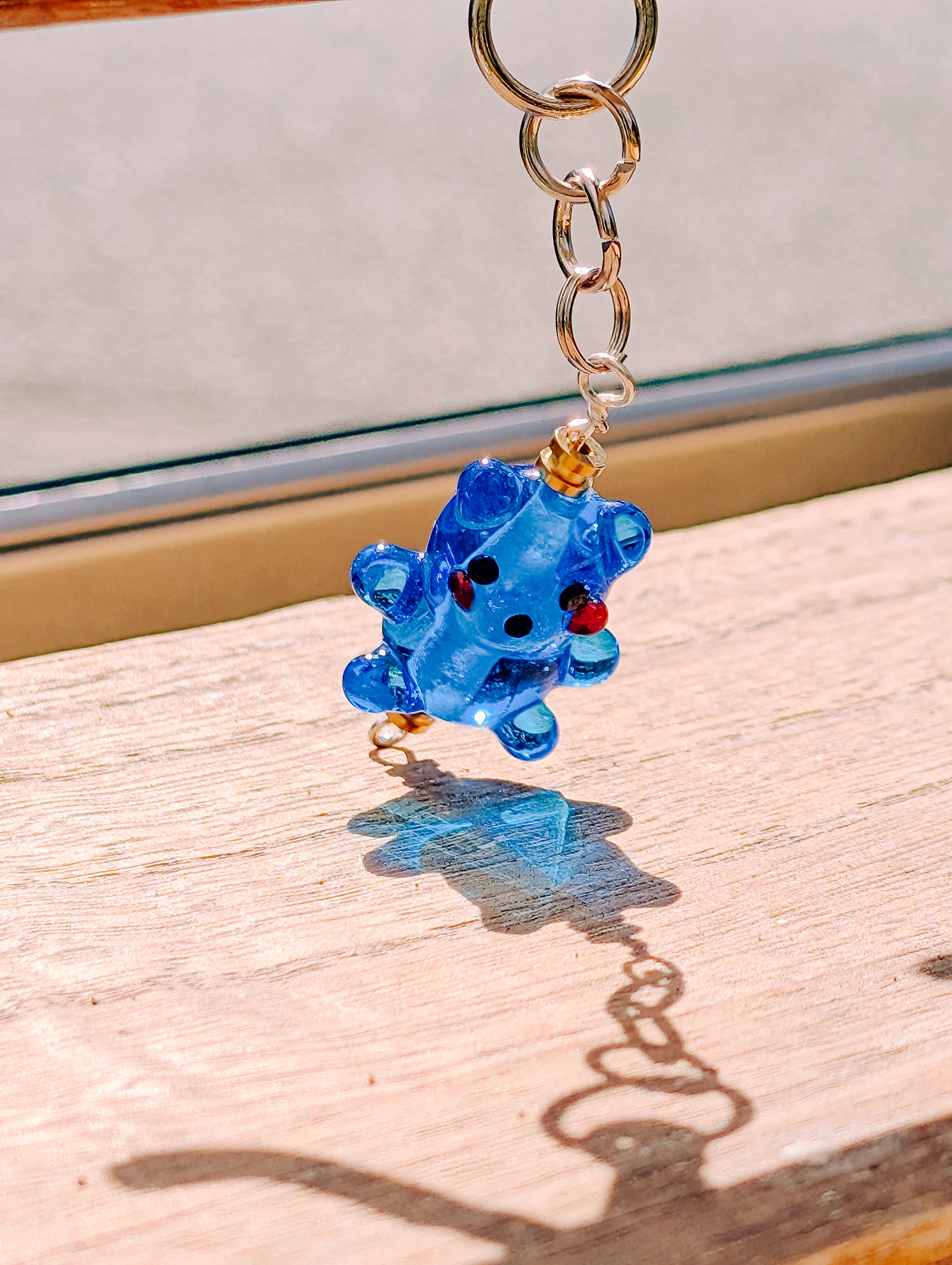 Blue glass bear charm hanging from a keychain