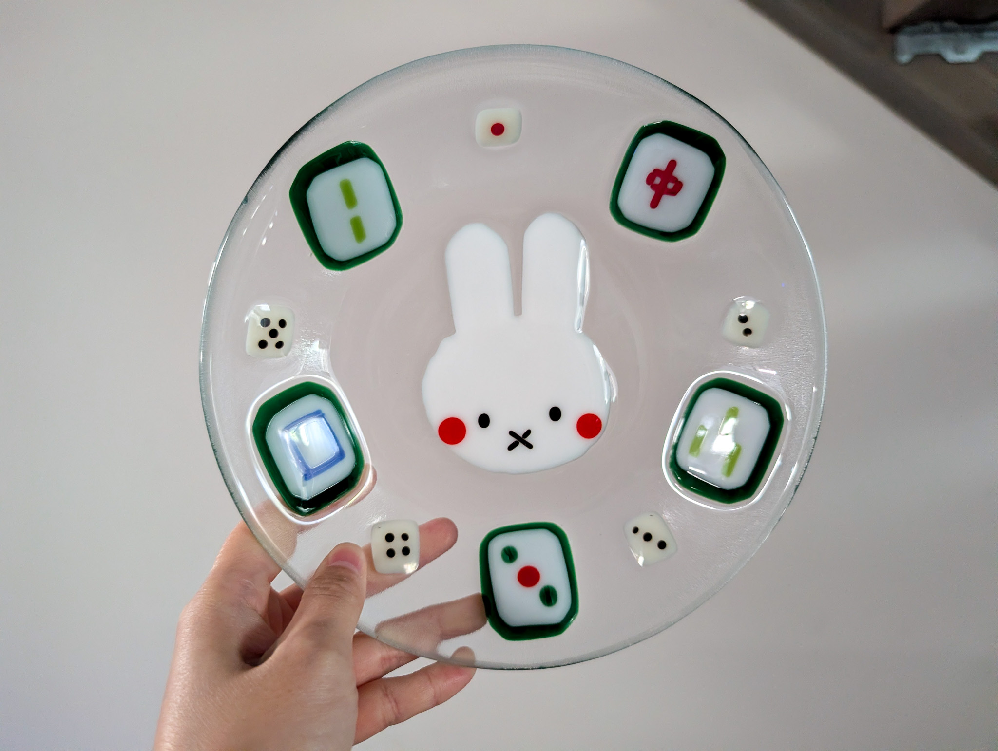 Round fused glass dish with a white bunny face and mahjong tile details